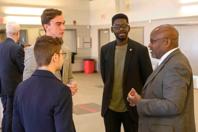 photo of chief justice with three pre-law students